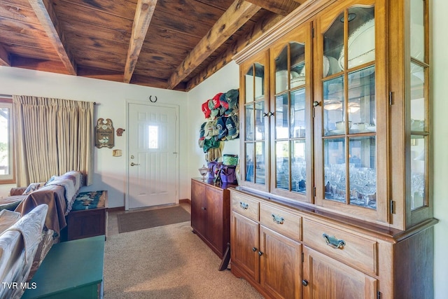 carpeted foyer featuring a wealth of natural light, beamed ceiling, and wooden ceiling