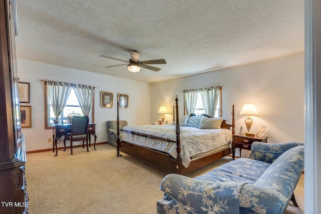 bedroom with light carpet, ceiling fan, and a textured ceiling