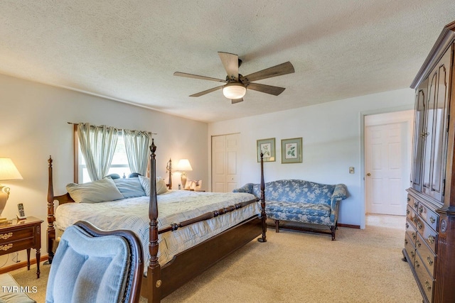 bedroom with ceiling fan, light colored carpet, a textured ceiling, and a closet