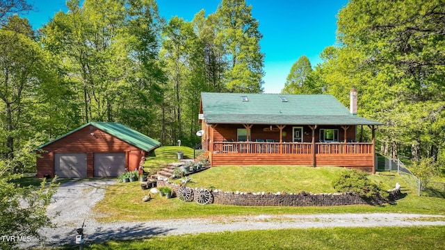 back of house featuring a garage, a lawn, a porch, and an outbuilding