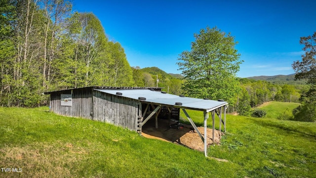 exterior space featuring a lawn and a mountain view