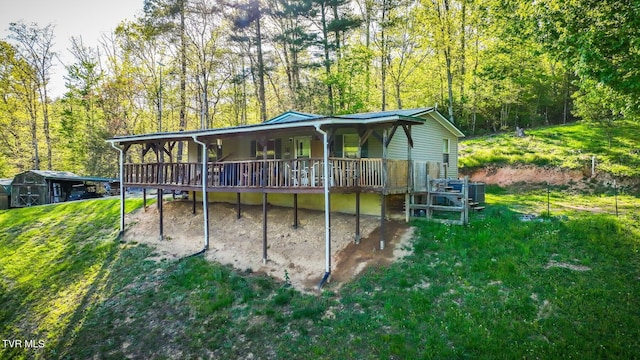 rear view of property with a deck and a yard