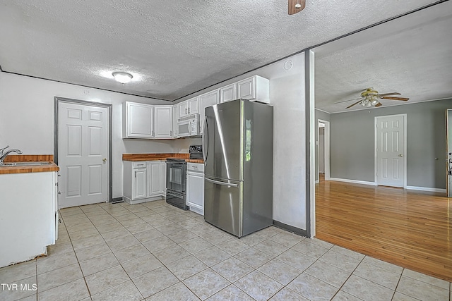 kitchen with light wood-type flooring, white cabinetry, ceiling fan, black range with electric cooktop, and stainless steel fridge