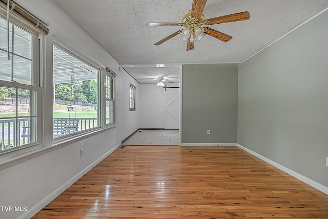 spare room featuring ceiling fan, a textured ceiling, and light hardwood / wood-style flooring