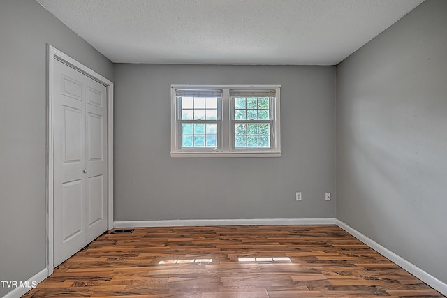 interior space featuring a textured ceiling and dark hardwood / wood-style flooring