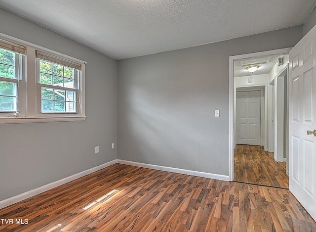 interior space featuring a textured ceiling and dark wood-type flooring