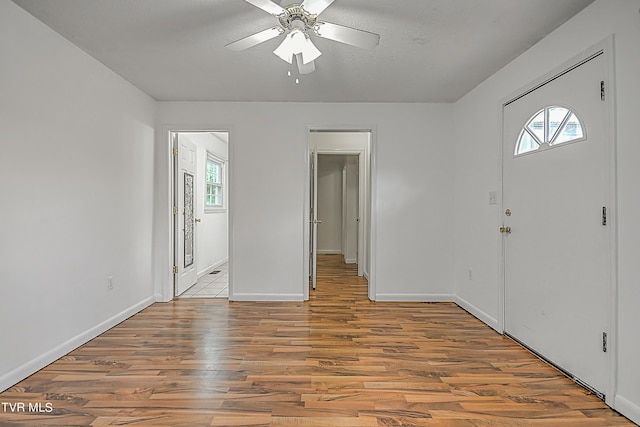 entrance foyer featuring a wealth of natural light, ceiling fan, and hardwood / wood-style flooring