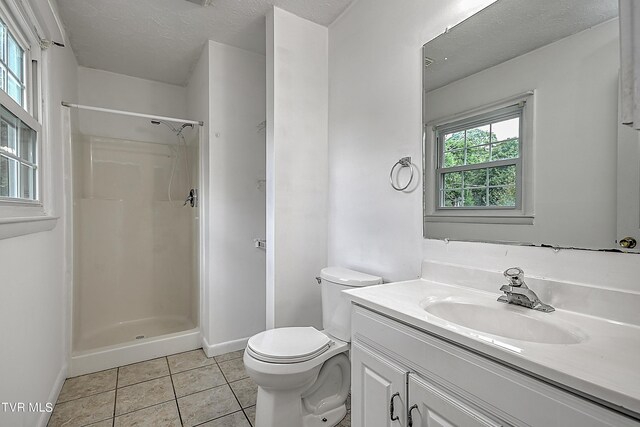 bathroom with walk in shower, vanity, toilet, and a wealth of natural light