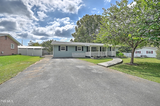 view of front of home with a front yard, a porch, and central AC unit