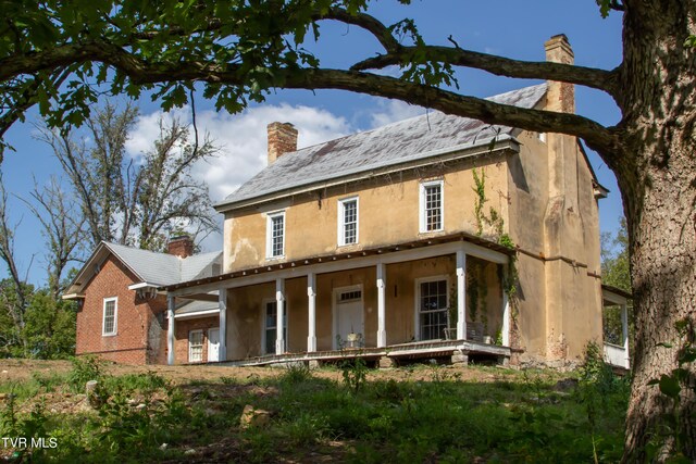2666 Main St, Surgoinsville, TN 37873 - view of front of house with a porch, stucco siding, and a chimney
