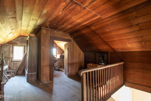 additional living space featuring wooden walls, wood ceiling, vaulted ceiling, and hardwood / wood-style flooring