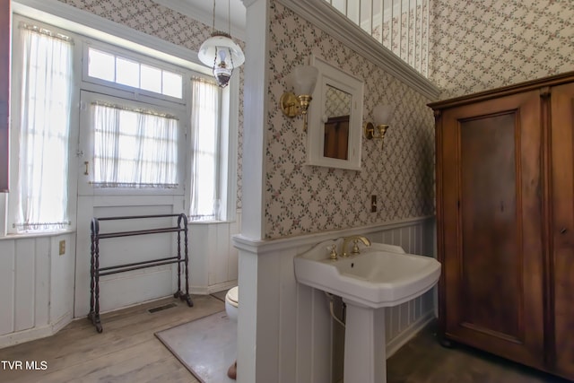 2666 Main St, Surgoinsville, TN 37873 - bathroom with toilet, wallpapered walls, a wainscoted wall, a sink, and wood finished floors