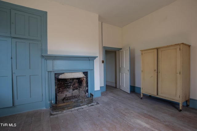 2666 Main St, Surgoinsville, TN 37873 - unfurnished living room with wood finished floors and a fireplace with raised hearth