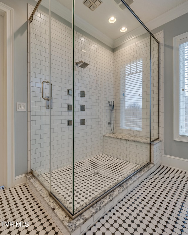 bathroom featuring tile patterned flooring, ornamental molding, and a shower with door