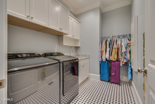 laundry room featuring ornamental molding, cabinets, sink, and washing machine and dryer