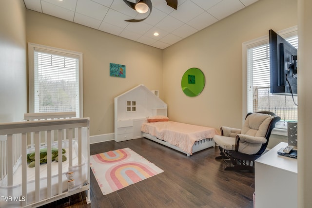 bedroom featuring multiple windows, dark hardwood / wood-style floors, and ceiling fan