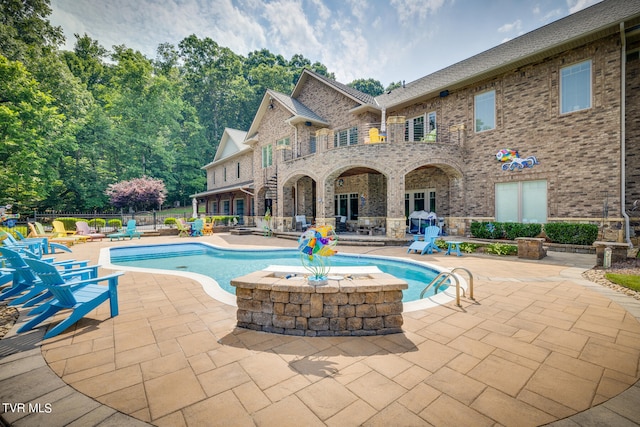 view of swimming pool with a hot tub and a patio area