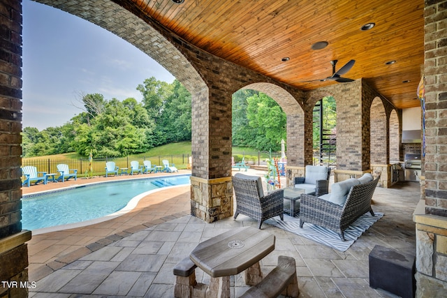 view of patio with ceiling fan, a fenced in pool, an outdoor hangout area, and exterior kitchen