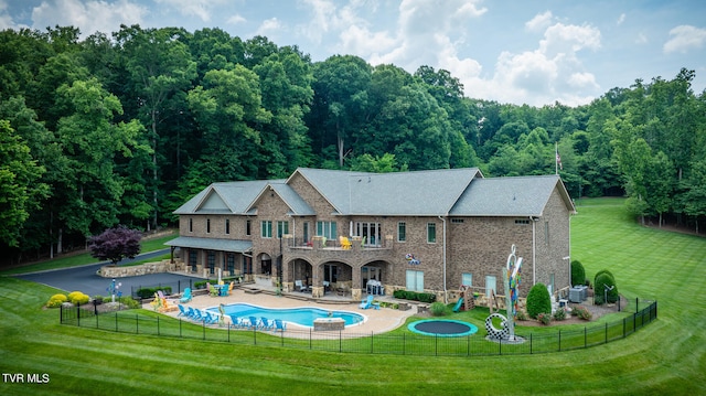 back of house featuring a lawn, a fenced in pool, a balcony, and a patio area