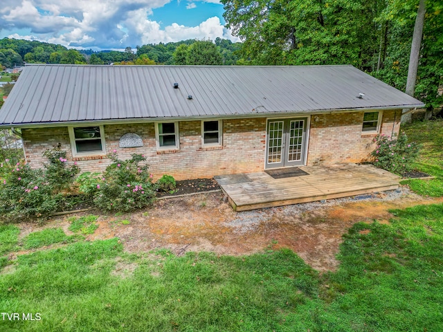 rear view of property featuring a wooden deck and a yard