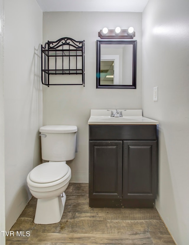 bathroom with hardwood / wood-style flooring, vanity, and toilet