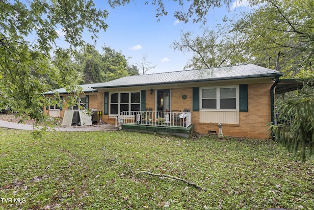 back of property with a yard and covered porch