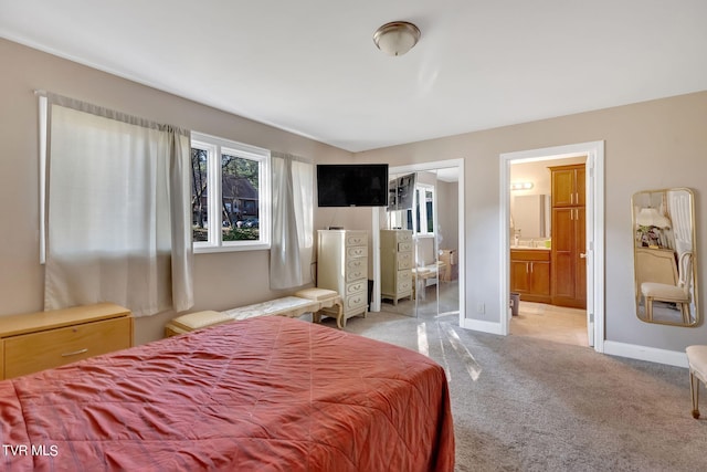 carpeted bedroom featuring connected bathroom