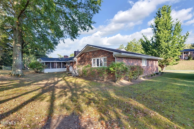 view of home's exterior featuring a sunroom and a yard