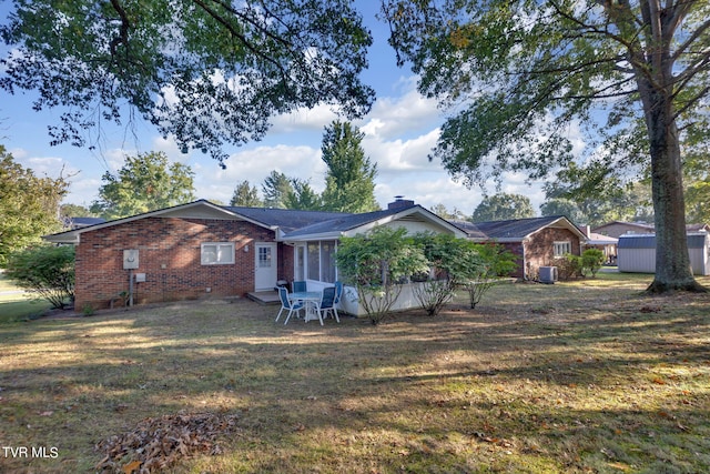 view of front of home with a front yard, a shed, and a patio area