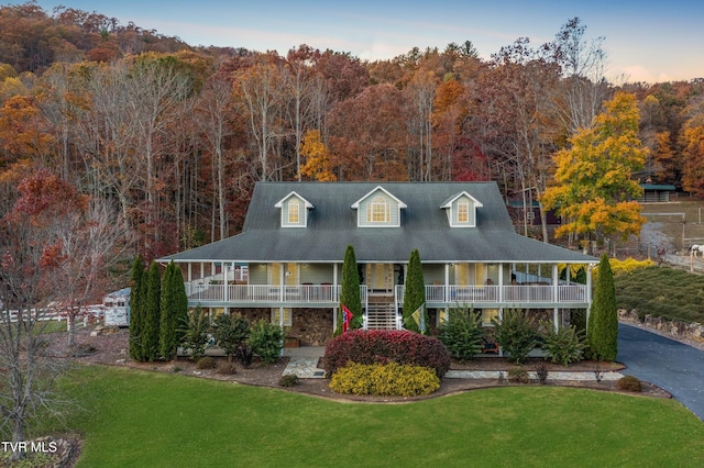 view of front of property with covered porch and a lawn