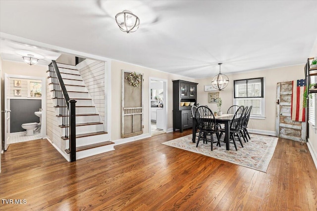 dining area with dark hardwood / wood-style floors and a notable chandelier