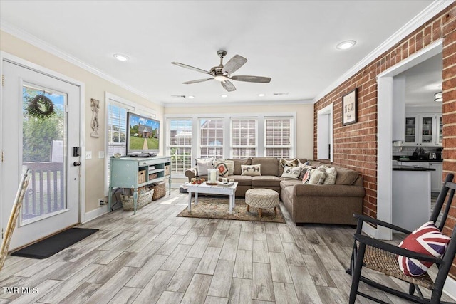 living room with ceiling fan, brick wall, light hardwood / wood-style flooring, and ornamental molding