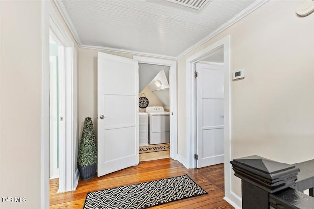 entryway with hardwood / wood-style flooring, crown molding, and washer and dryer