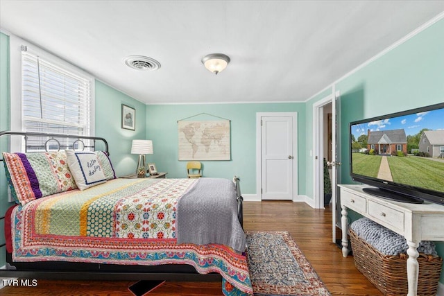 bedroom with ornamental molding and dark hardwood / wood-style flooring