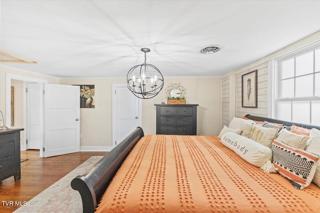 bedroom featuring wood-type flooring and a chandelier