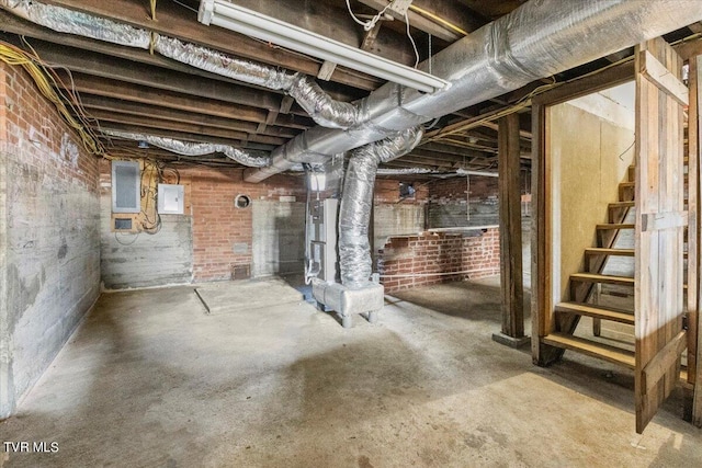 basement featuring brick wall and electric panel