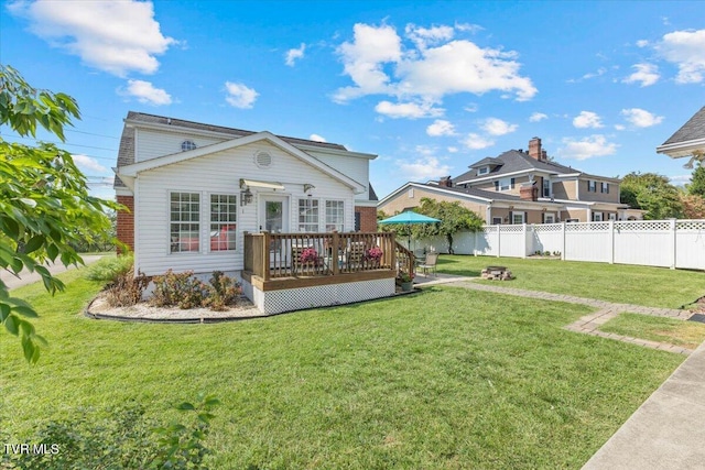 rear view of property featuring a lawn and a deck