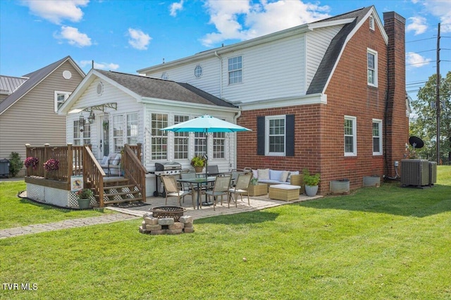 rear view of house with a deck, an outdoor living space with a fire pit, cooling unit, a patio area, and a yard