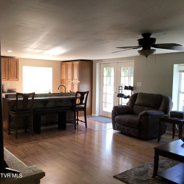 living room with hardwood / wood-style flooring, ceiling fan, and french doors