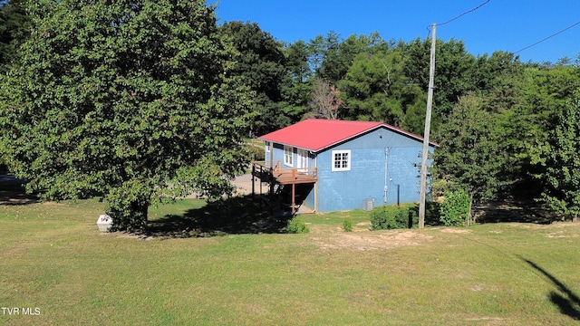 exterior space with a deck and a lawn