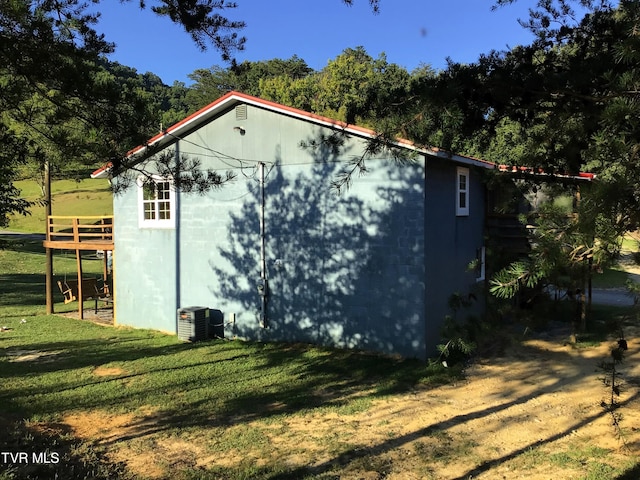 view of outdoor structure with central AC and a yard