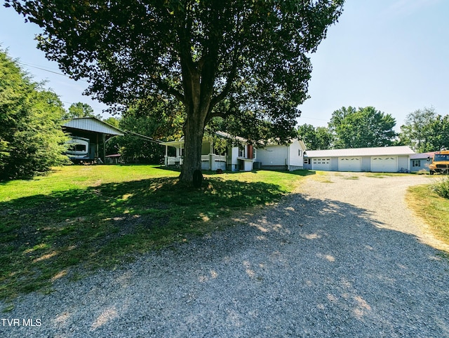 view of front of house featuring a front yard, a garage, and an outdoor structure