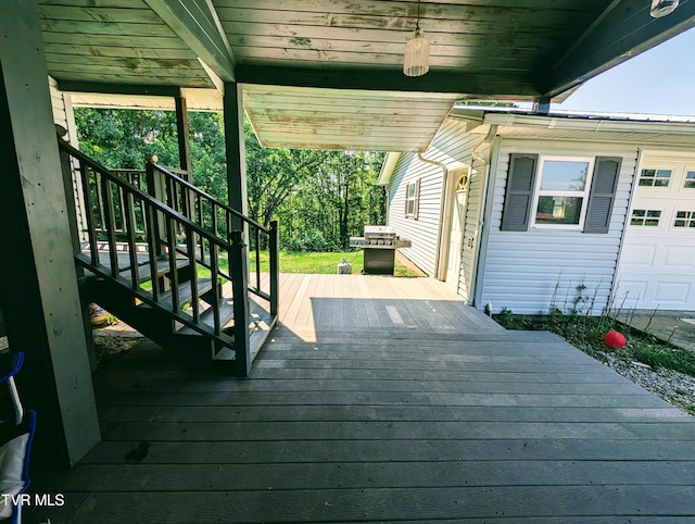 wooden terrace featuring area for grilling and a garage