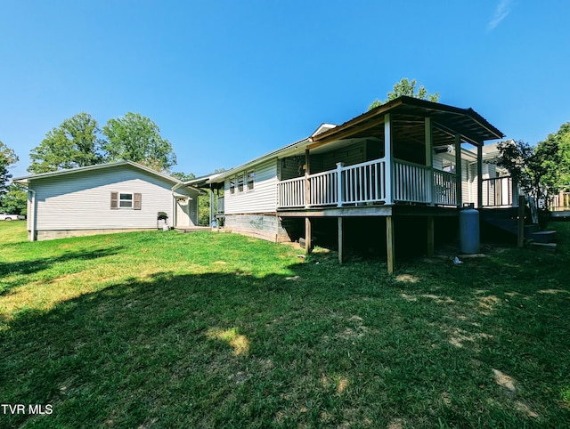 rear view of property with a lawn and a wooden deck