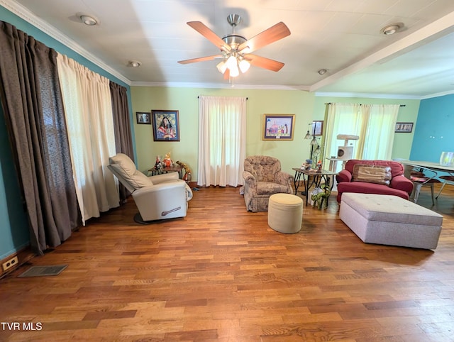 living room with light hardwood / wood-style floors, ornamental molding, and ceiling fan