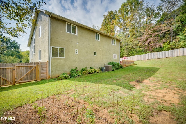 back of property featuring a lawn and central AC unit