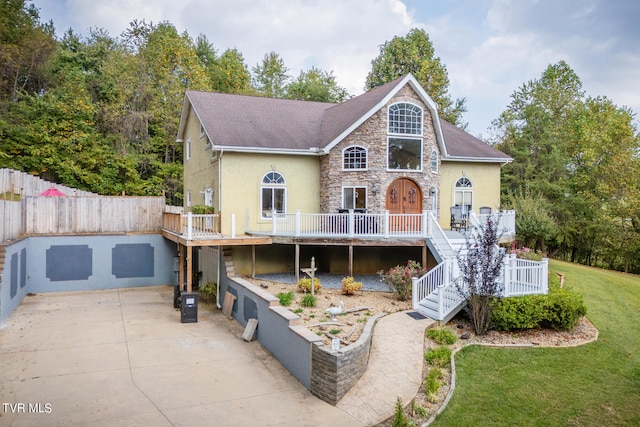 view of front of house with a front yard, a deck, and a garage