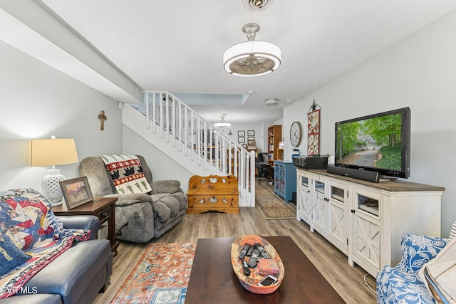 living room featuring a textured ceiling and light hardwood / wood-style flooring