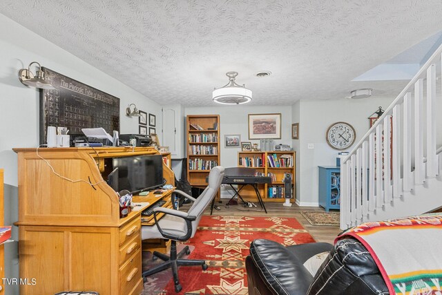 office area with a textured ceiling and hardwood / wood-style floors