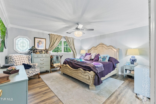 bedroom with ornamental molding, wood-type flooring, ceiling fan, and a textured ceiling